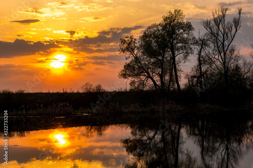 Fototapeta Naklejka Na Ścianę i Meble -  Colorful sunset behind the clouds above the water