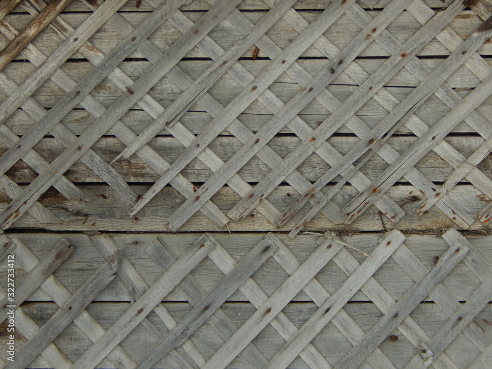 old cladding of a wooden building made of thin crossed planks old cladding of a wooden building made of thin crossed planks