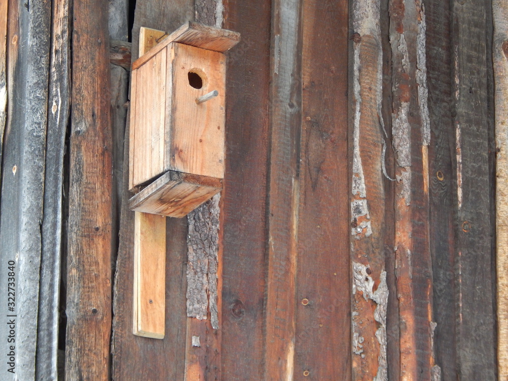 old birdhouse nailed to the textured wall of a wooden house old birdhouse nailed to the textured wall of a wooden house
