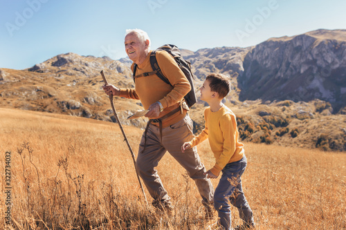 Senior man with grandson on country walk in autumn. photo