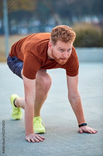 Young modern man jogging / exercising in an urban park.