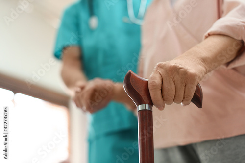 Medical worker taking care of elderly woman in geriatric hospice, closeup