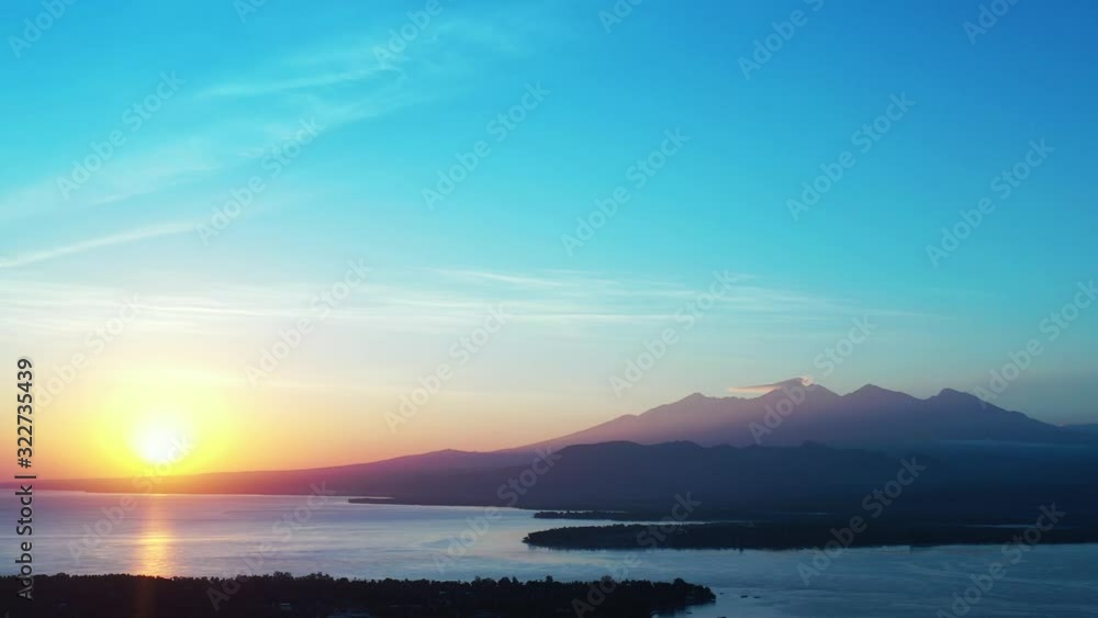 Beautiful golden sunrise during an early morning over mountains and reflecting into the water Beautiful golden sunrise during an early morning over mountains and reflecting into the water