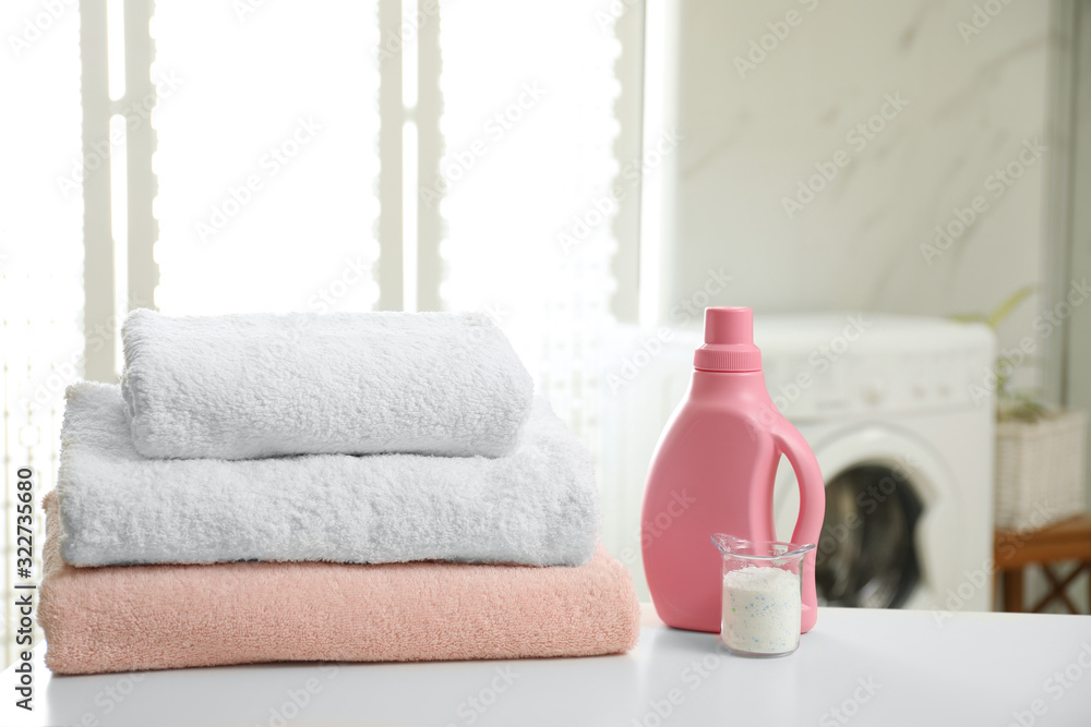 Clean towels and detergents on table in laundry room