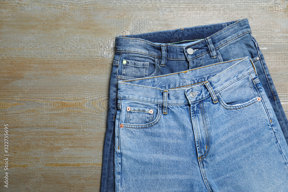 New stylish jeans on wooden background, flat lay New stylish jeans on wooden background, flat lay