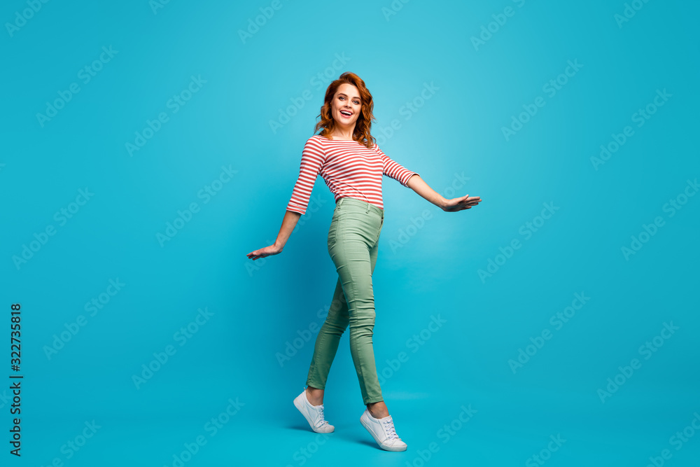 Full body profile photo of funny lady enjoy warm spring day spend active time walk street wear casual red white pullover green pants footwear isolated blue color background