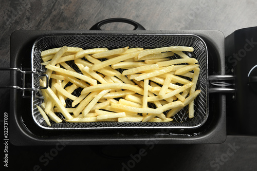 Cooking delicious french fries in hot oil, top view