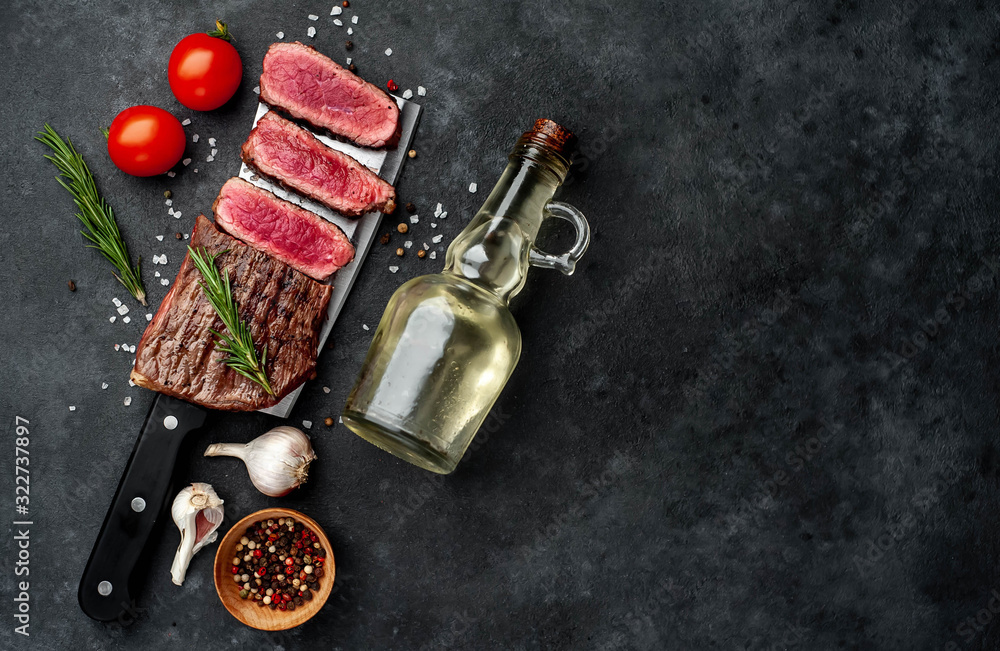 grilled steak over meat knife with spices on a stone background with copy space for your text grilled steak over meat knife with spices on a stone background with copy space for your text