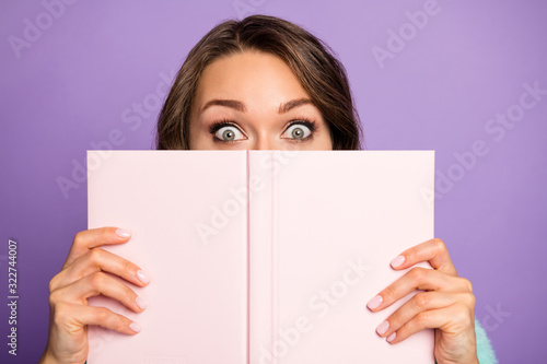 Closeup photo of crazy pretty lady hold planner copybook hiding half facial expression shy person big eyes wear sweater isolated purple color background