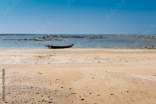 Longboat on beach with rocks in background
