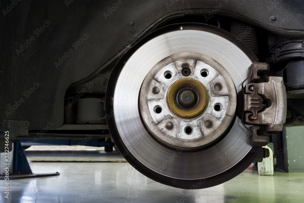 Brake disc with calliper of car in garage for repair in process, Close up Brake Disc car.