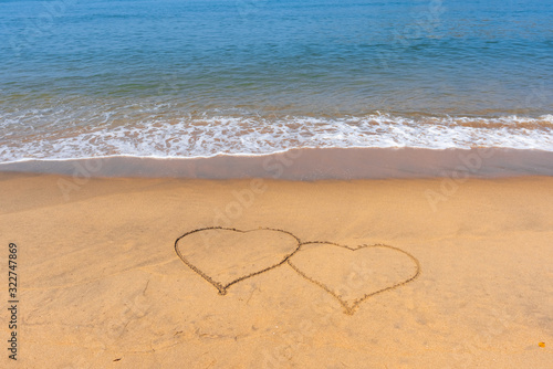 14 February. Valentine s Day. Two hearts drawn in the sand. Day of lovers. Congratulations. Sandy tropical beach with painted hearts. 