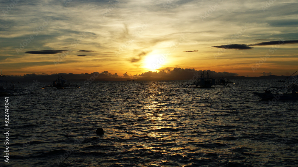 tropical island and fishing boats at sunset