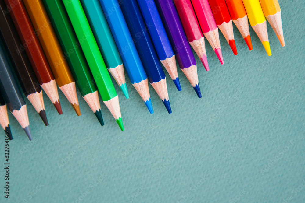 flat lay on the theme of drawing and creativity: color pencils on a green background, place for text flat lay on the theme of drawing and creativity: color pencils on a green background, place for text
