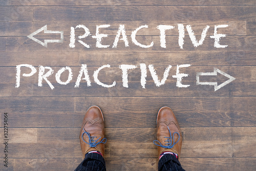 Canvas Print Man looking down at the words REACTIVE and PROACTIVE written on the floor