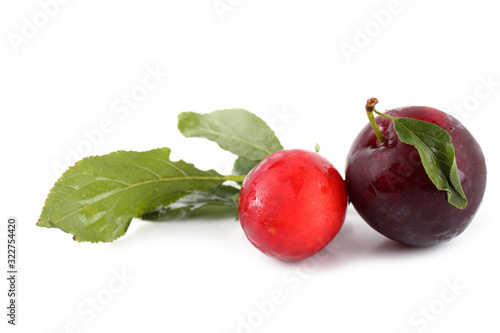 Red plums and leaves isolated on white