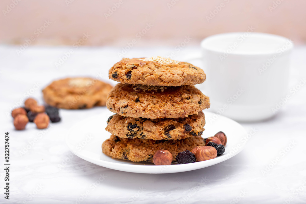 Fresh oatmeal friable cookies on a plate with nuts and raisins. The concept of a delicious and healthy breakfast. Fresh oatmeal friable cookies on a plate with nuts and raisins. The concept of a delicious and healthy breakfast.