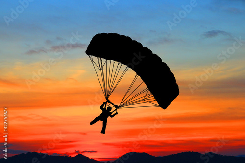 Silhouette Skydiver in sky on sunrise