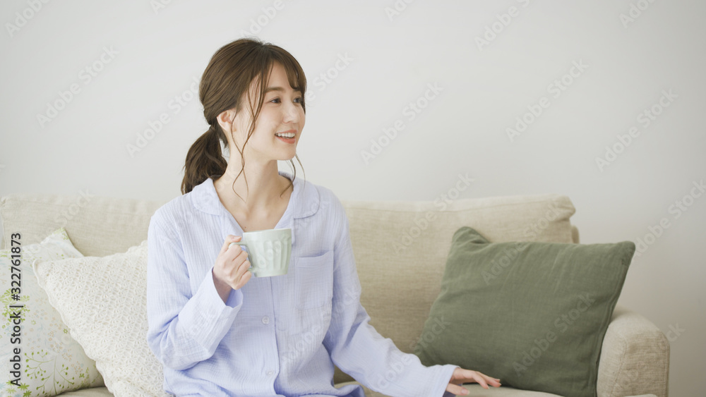パジャマ姿でマグカップを持つ女性