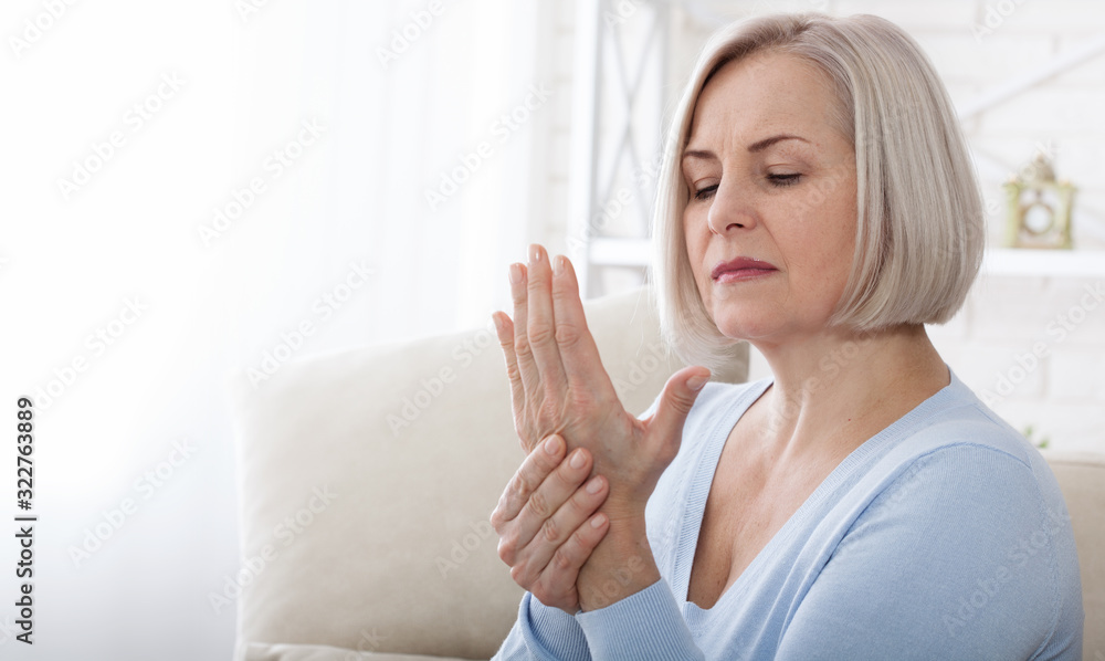 Woman massaging her arthritic hand and wrist Woman massaging her arthritic hand and wrist