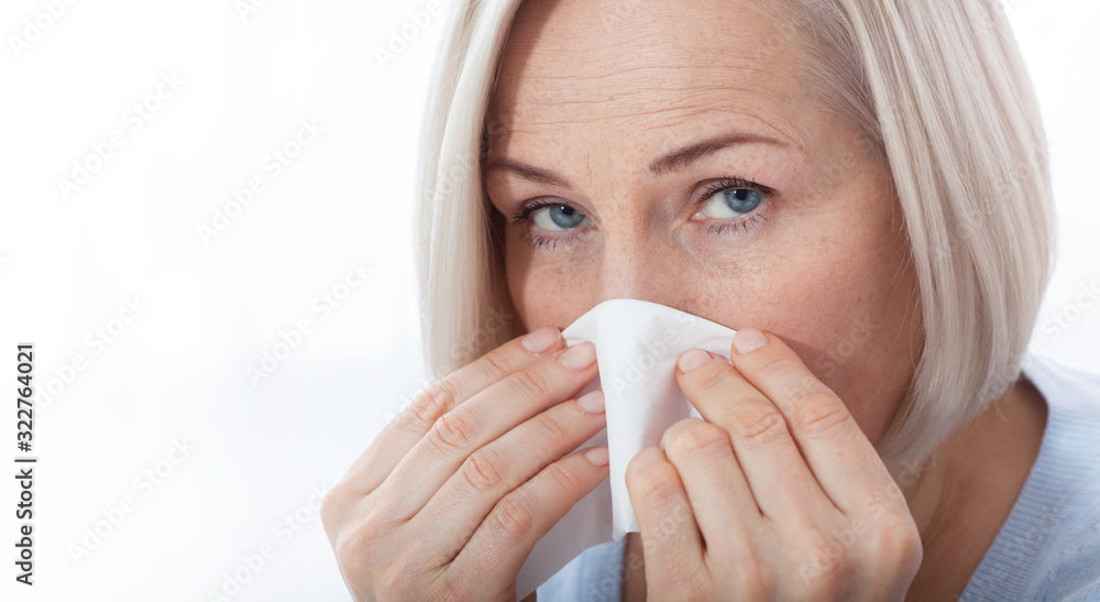 Healthcare, cold, allergy and people concept, sick woman blowing her runny nose in paper tissue on white background Healthcare, cold, allergy and people concept, sick woman blowing her runny nose in paper tissue on white background