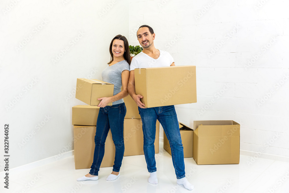 Packed and ready to move in new house. Excited young spouses with boxes in hands, on their way into new apartments. Packed and ready to move in new house. Excited young spouses with boxes in hands, on their way into new apartments.
