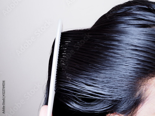Hair and scalp health care By combing black hair and long on head with white comb.