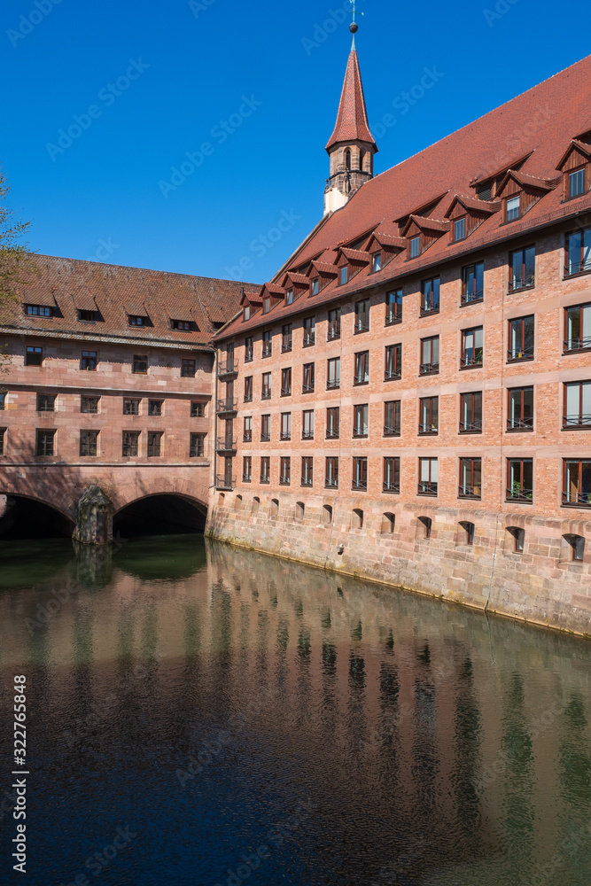 Obraz premium Blick auf das Heilig-Geist-Spital am Fluss Pegnitz in Nürnberg/Deutschland