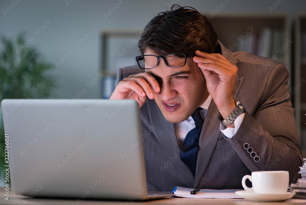 Businessman staying in the office for long hours Businessman staying in the office for long hours