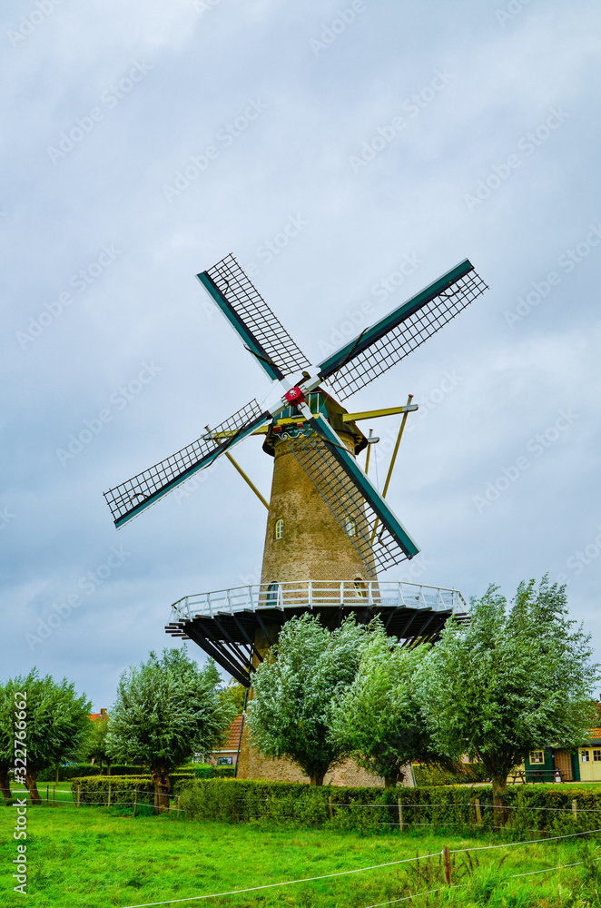 Obraz premium Goes, the netherlands, august 2019. In the countryside of the zealand region, a perfectly preserved and functioning windmill. Typical postcard landscape of the Dutch countryside.