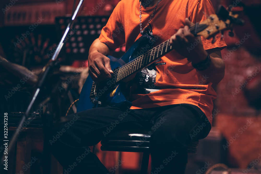 Obraz premium man hand playing guitar acoustic and singing on the stage at night.