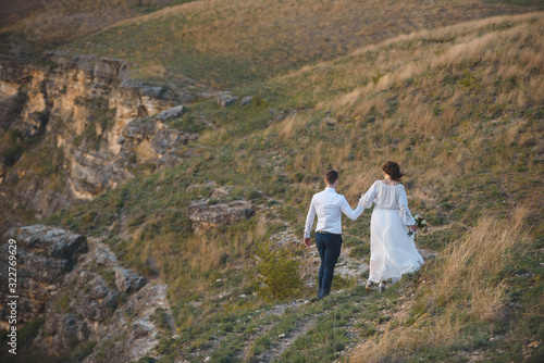bride and groom walking on hill © photographmd