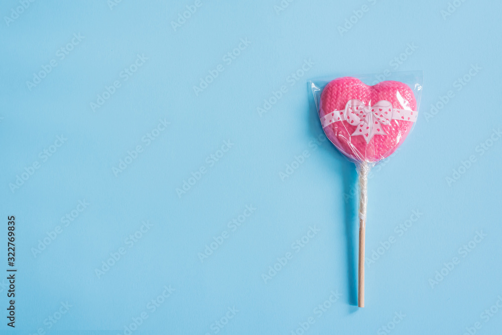 heart shaped lollipop over blue background