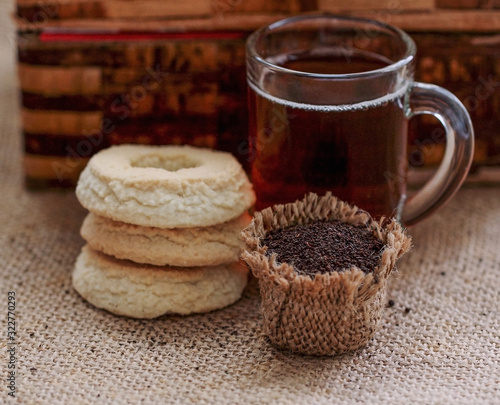 Bag of dry Kenia tea,in back glass of tea and cookie