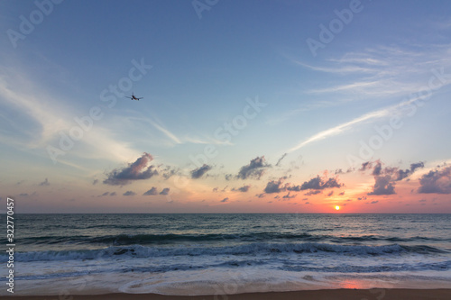 An aircraft flying towards vibrant pink sunset
