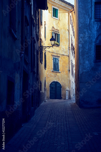 Old magic mysterious narrow Italian street view from dramatic backstreet on the old house with yellow ragged facade, ancient medieval heritage © Antonio