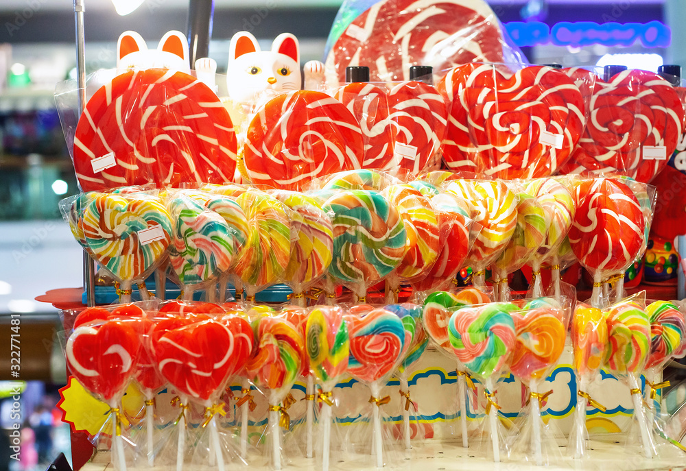 Different colorful candy canes caramel on stick in sweet shop