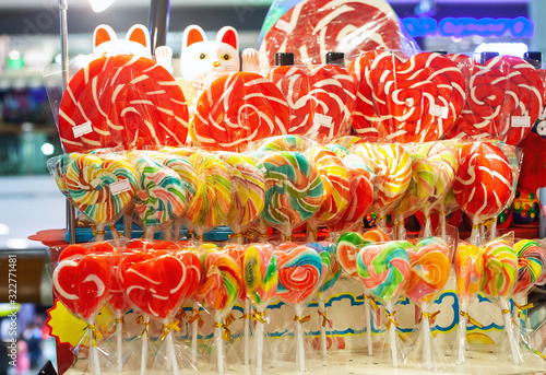 Different colorful candy canes caramel on stick in sweet shop