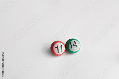 a small billiard ball of pink ang green color with the number 11 and number 14 on a white light background
