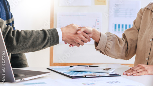 Good deal career and placement concept, successful young businessmen shaking hands after successful negotiation in modern office.