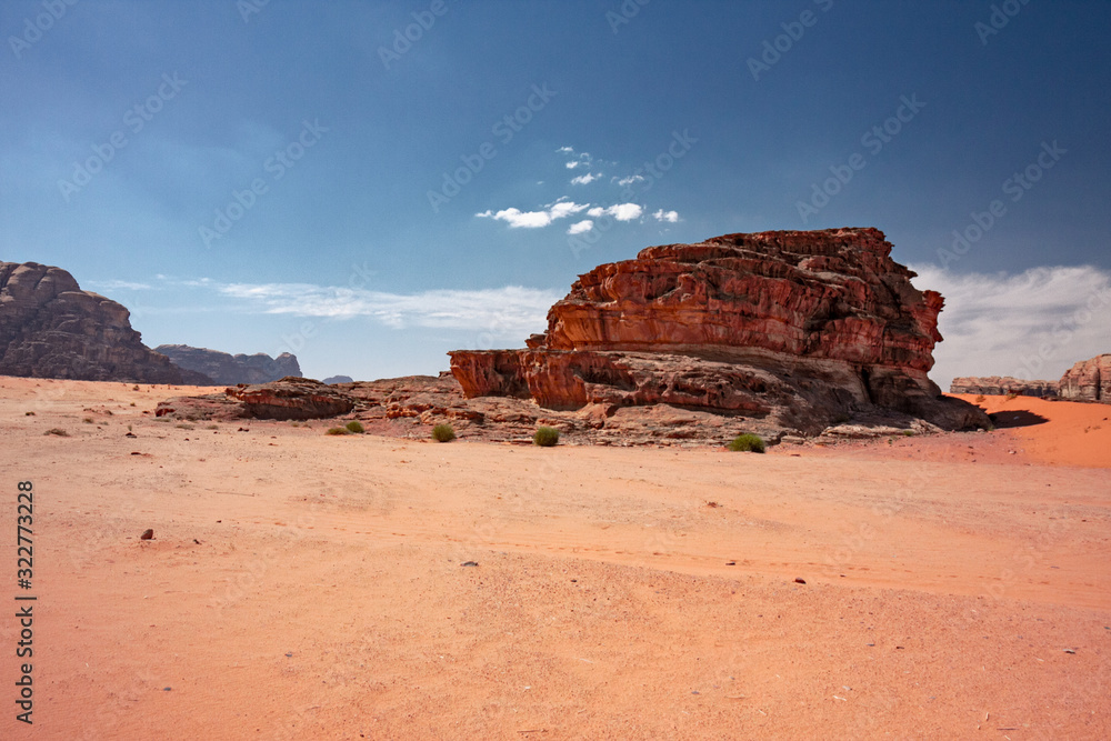 Panoramic view of rocky mountains and red sand in the Jordanian desert of Wadi Rum.