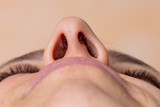 Nose of a woman seen from below. Laser hair removal concept of nose hair