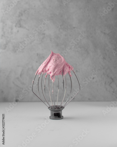 Pink american buttercream on a whisk attachment