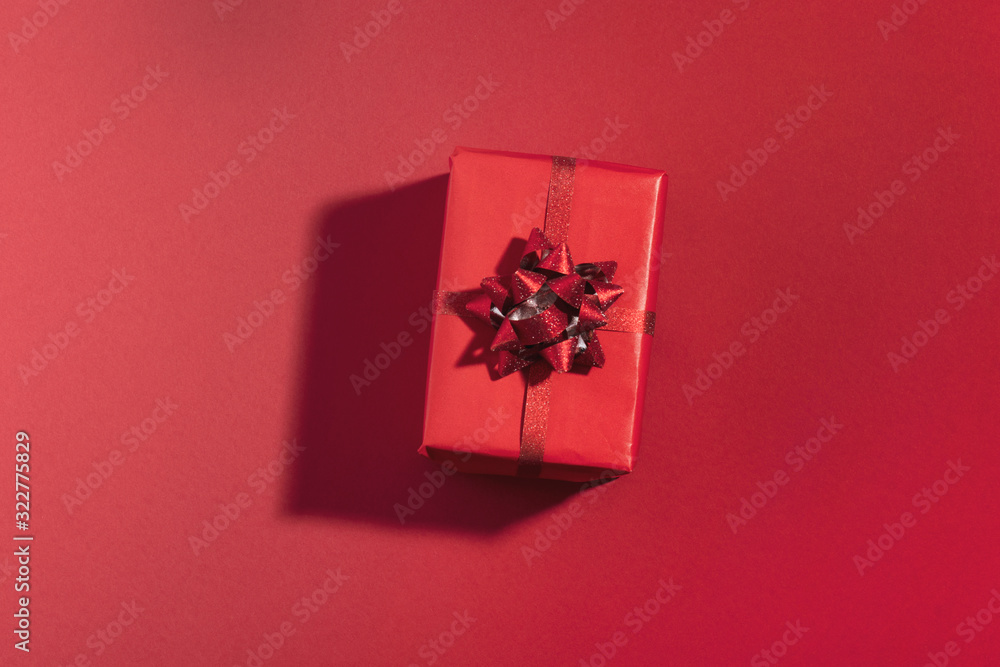 Gift box with shadow on red surface. Top view, flat lay Gift box with shadow on red surface. Top view, flat lay