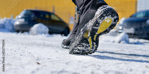 male or female winter boots walking on snowy sleet road	 photo