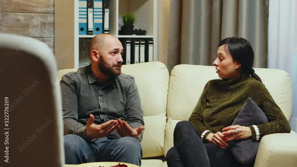 Young man telling his wife in front of therapist Young man telling his wife in front of therapist