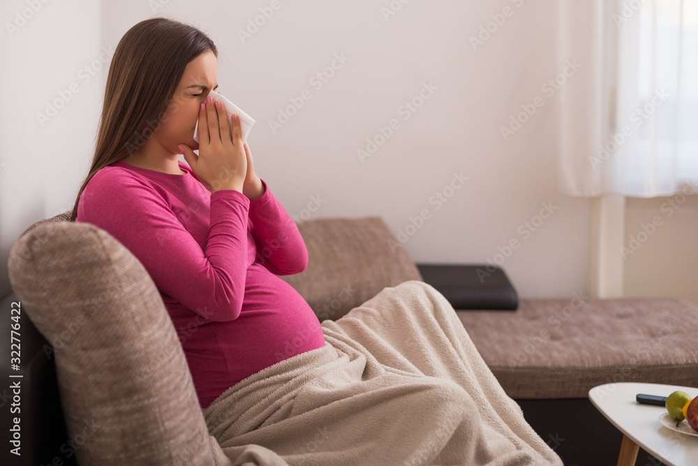 Exhausted pregnant woman having flu and blowing nose. Exhausted pregnant woman having flu and blowing nose.