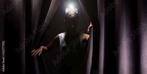 Fototapeta Naklejka Na Ścianę i Meble -  Miss Pageant Beauty Contest wears sequin Evening Gown long dress with sparkle Diamond Crown, Asian Woman opens purple Curtain after win Final round as new way life, opportunity, change everything
