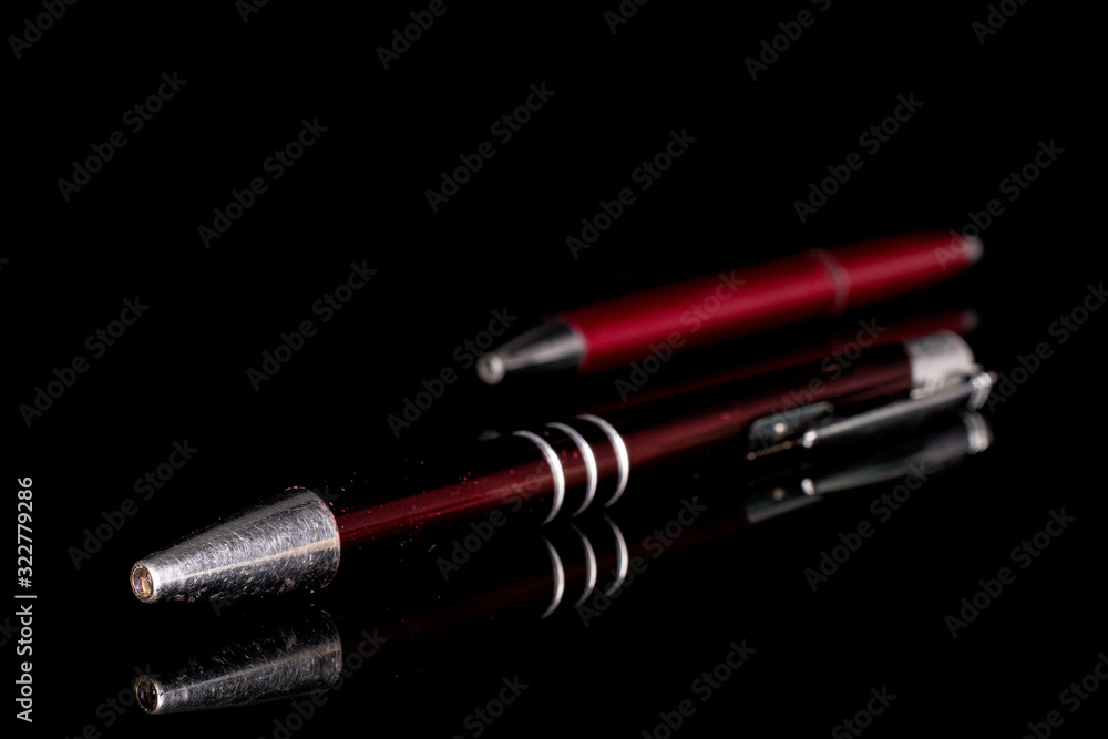 Group of two whole red writing ballpoint pen isolated on black glass Group of two whole red writing ballpoint pen isolated on black glass