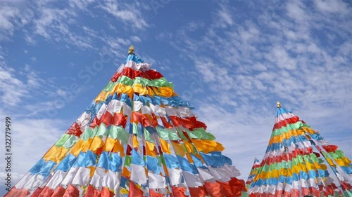 Colorful prayer flags flown in the wind and blue sky cloud in slow motion.
